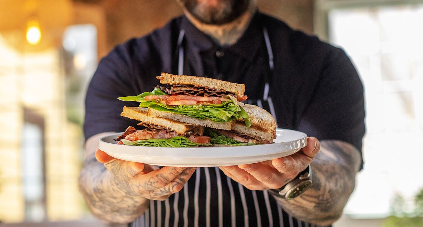 Man holds mycelium bacon sandwich